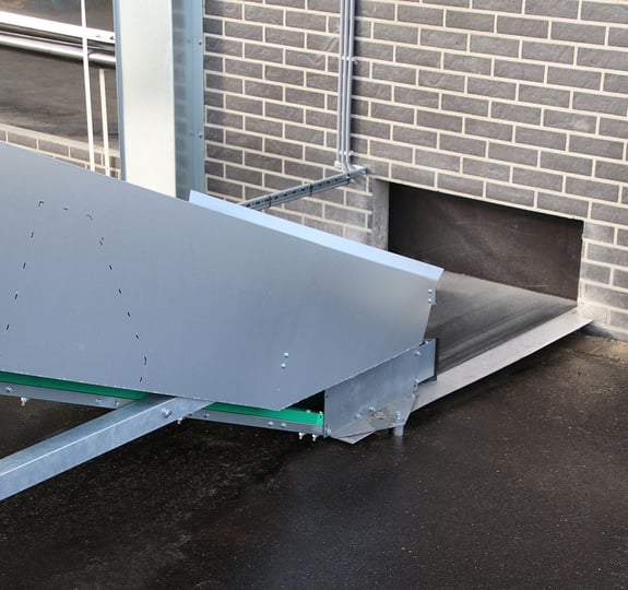 floor-mounted manure conveyor drive and discharge layout